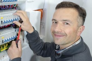 Ein Elektriker sorgt bei einem Firmenumzug in Hamburg für die fachgerechte Einrichtung des Sicherungskastens. 