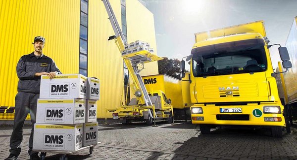 Ein Mitarbeiter steht mit gepackten Umzugskartons vor dem Firmengebäude, das im Rahmen eines Firmenumzugs in Hamburg leergeräumt wird.