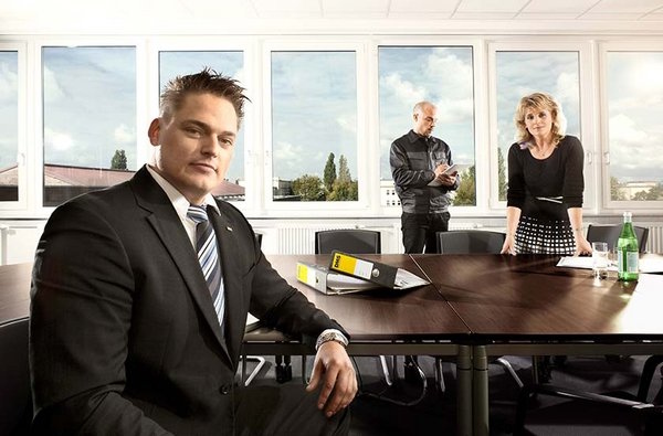 Zwei Mitarbeiter besprechen mit einer Unternehmerin die Planung Ihres Büroumzugs in Hamburg. 