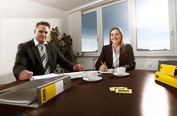 Zwei Mitarbeitende stellen einem unserer Kunden geeignete Versicherungen für einen Firmenumzug in Hamburg vor. 