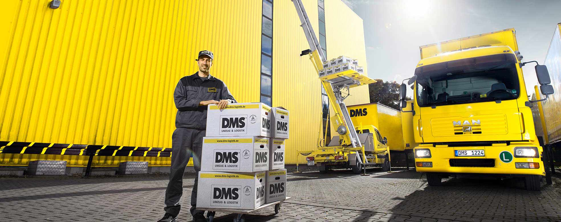 Ein Mitarbeiter steht mit gepackten Umzugskartons vor dem Firmengebäude, das im Rahmen eines Firmenumzugs in Hamburg leergeräumt wird.